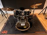 a drum set that is sitting on a mat in front of a microphone