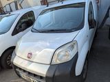 trois fourgonnettes blanches garées sur un parking, avec des graffitis sur le côté du bâtiment