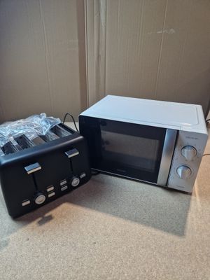 un micro-ondes et un grille-pain posés l'un à côté de l'autre sur le sol