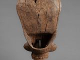 a wooden sculpture of a shell on a stand on a gray background