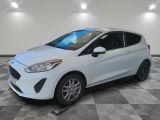 a white ford fiesta parked on a checkered tile floor