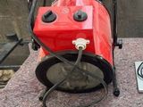a red blower sitting on top of a table next to a laptop