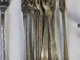 a lot of forks and spoons that are on the table