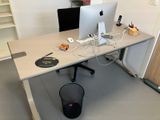un bureau sur lequel se trouvent deux ordinateurs et une poubelle