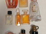 many different bottles of perfume on a white surface