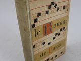 un vieux livre portant une étiquette rouge, posé sur une surface blanche