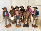 seven figurines of men dressed in different outfits