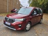 une voiture rouge garée devant un immeuble en briques