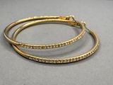 une paire de boucles d'oreilles créoles en or serties de diamants