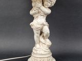 an image of a statue of a child holding a lamp