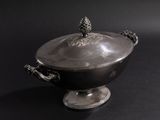a silver bowl with a lid on a black surface