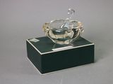 a glass bowl with a bird on it on a stand