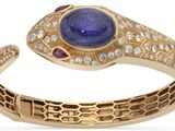gros plan d'une bague avec une pierre bleue et des diamants