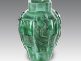 a green vase with a picture of a woman on it