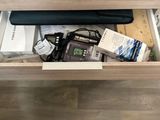 a drawer that has a laptop and other items in it