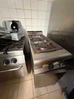 deux cuisinières dans une cuisine, surmontées d'un ventilateur