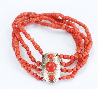 a close up of a red beaded necklace with a silver clasp