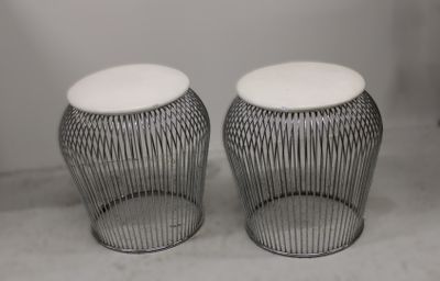 deux tabourets en métal surmontés de coussins blancs