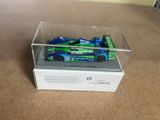 a small toy car in a clear box on the floor