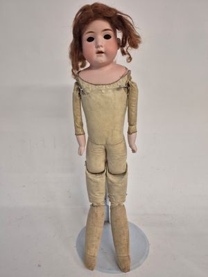 a small doll that is standing on a white surface