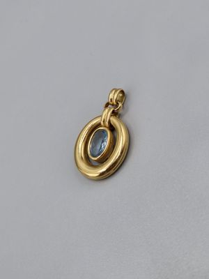 une image représentant un pendentif en or orné d'une pierre bleue