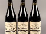 trois bouteilles de vin posées sur une table l'une à côté de l'autre