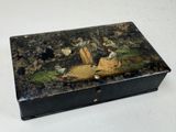 une boîte noire ornée d'une peinture, posée sur une table