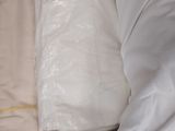 a box full of white sheets and pillows on the floor