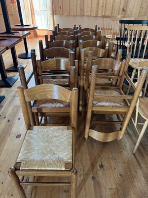 de nombreuses chaises en bois alignées en rang dans une pièce