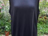 a woman ' s dress on a mannequin stand in front of a building