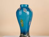 a blue vase sitting on top of a white table