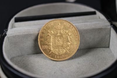 une pièce d'or posée dans un écrin sur une table