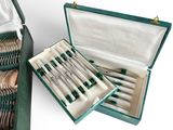 a green case with silverware in it on a white surface
