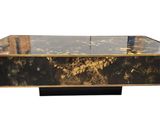 une photo d'une table basse noire et dorée avec un plateau en verre