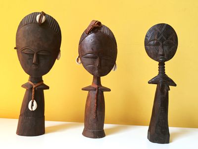 trois figurines en bois posées sur une table