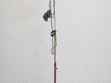 a metal sculpture with a wooden base and a light bulb on top of it