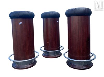 trois socles en bois avec des plateaux en cuir noir et une base en métal