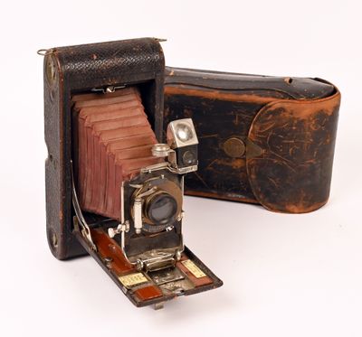 an old photo of an old camera with a leather case