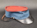 blue and red hat with a leather strap on a black surface