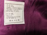 a close up of a label on a purple satin jacket