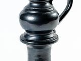 un vase noir posé sur une surface blanche