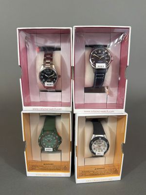 trois boîtes contenant chacune une montre différente, posées sur une table