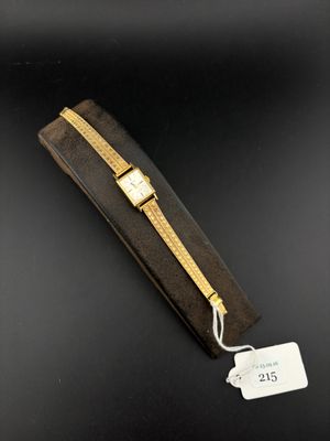 a gold watch with a black case and a tag on it