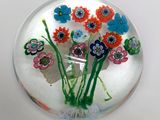 une assiette en verre contenant des fleurs, posée sur une table