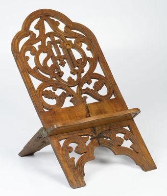 une vieille chaise en bois dont le dossier et l'assise sont sculptés, sur fond blanc