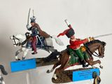 three figurines of men riding horses on display