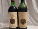 two bottles of wine sitting next to each other on a table