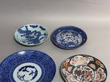 four blue and white plates sitting on top of a table