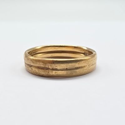 two gold wedding rings on a white surface