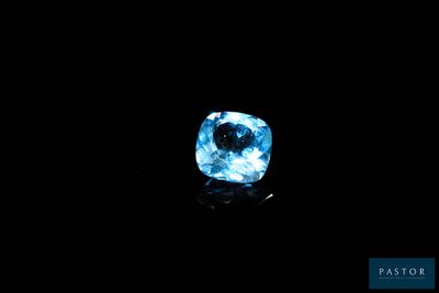 un diamant bleu dans l'obscurité, sur fond noir